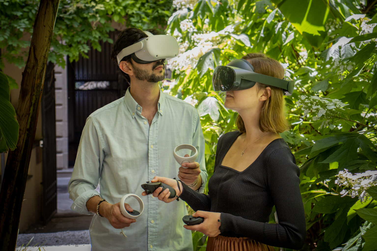 Team members with VR headsets in a garden, engaging with virtual content in a lush setting.